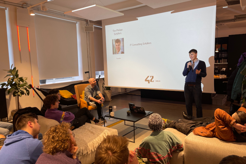 Vortrag von Tim Philipp Schäfers (Person steht vor anderen und hält einen Vortrag)